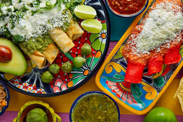Green and red enchiladas with mexican sauces Green and red enchiladas with mexican sauces mix in colorful table enchilada stock pictures, royalty-free photos & images