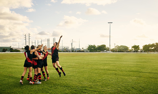 Shot of a women’s football team celebrating a win on the field