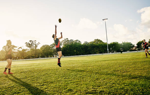The harder you work, the harder it is to lose Shot of a group of young women out on the field for a game of football sports training australia stock pictures, royalty-free photos & images