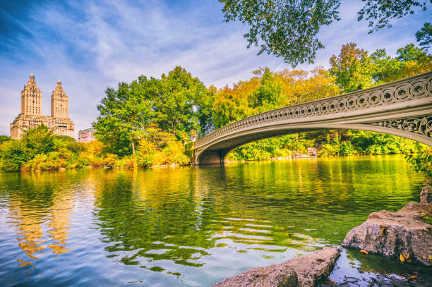 bow bridge in Central Park at Autumn New York Manhattan photo Bow Brige with people in Central Park at autumn in Manhattan. New York City. USA san remo apartments photos stock pictures, royalty-free photos & images