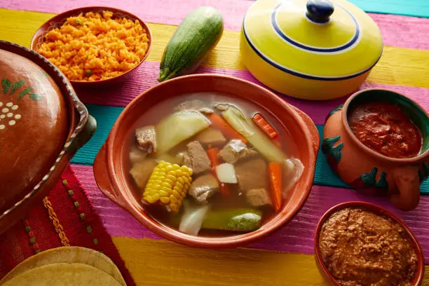 Caldo de res Mexican beef broth in table with sauces