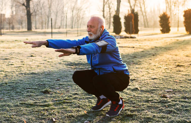 jogger senior che fa stretching - adult jogging running motivation foto e immagini stock