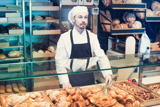 istock Young male pastry maker demonstrating croissant 913661580
