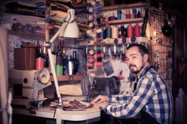 istock male worker sewing stitches on belt in leather workshop 913661716