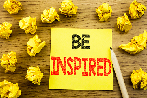 Word, writing Be Inspired. Business concept for Inspiration and Motivation written on sticky note paper on wooden background. Folded yellow papers on the background