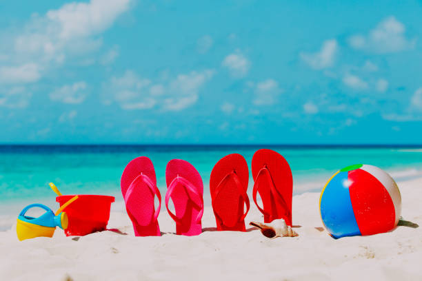 istock Colored flip-flops, toys and diving mask at beach 913664570