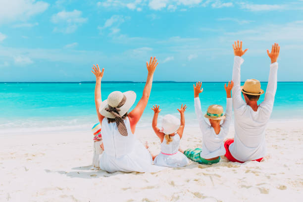 istock happy family with two kids hands up on beach 913665852