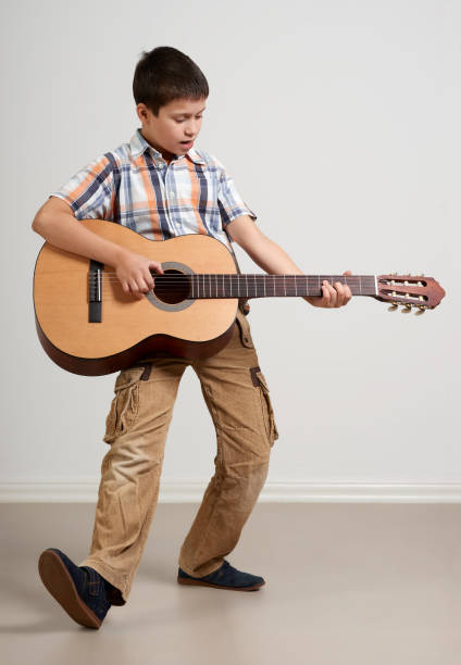 istock Boy is playing the acoustic guitar on white background 913666212