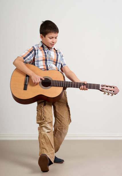 istock Boy is playing the acoustic guitar on white background 913666256
