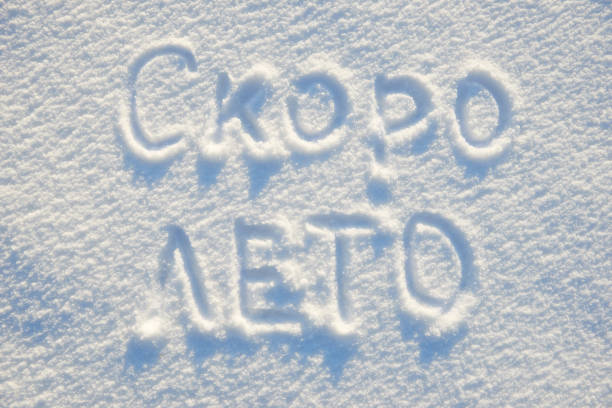 istock summer is coming text written russian language on snow for texture or background - winter holiday concept. Sunny day, bright light with shadows, flat lay, top view, clean and nobody 913673976
