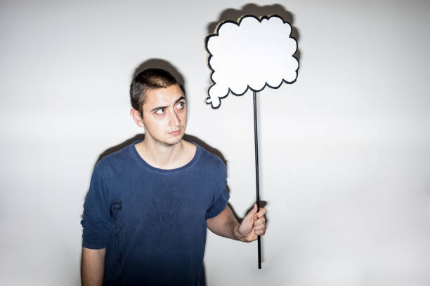 istock Pensive Young Adult Holding a Cloud Shaped Speech Bubble 913676464