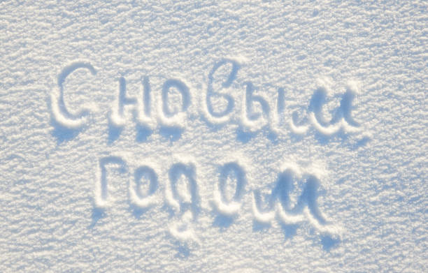 istock Happy New year text written on russian language on snow for texture or background - winter holiday concept. Sunny day, bright light with shadows, flat lay, top view, clean and nobody 913676980