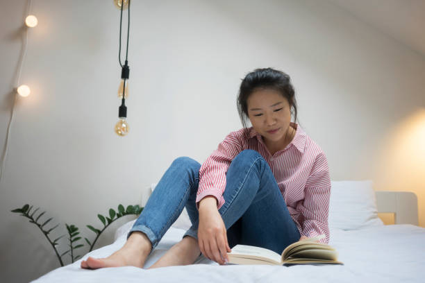 istock Young Chinese woman reading book 913678664