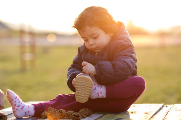 Little girl putting on her shoe