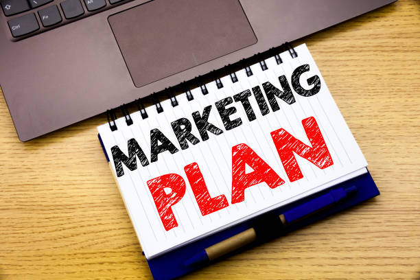Hand writing text caption inspiration showing Marketing Plan. Business concept for Planning Successful Strategy written on notebook book on wooden background in the Office with laptop inspiración de leyenda de texto que muestra el plan de marketing de la escritura a mano. concepto de negocio para la planificación exitosa estrategia escrito en el libro de notebook en el fondo de madera en la oficina con ordenador portátil