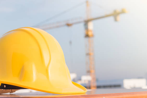 istock The yellow safety helmet on the table at construction site with crane background 913689300