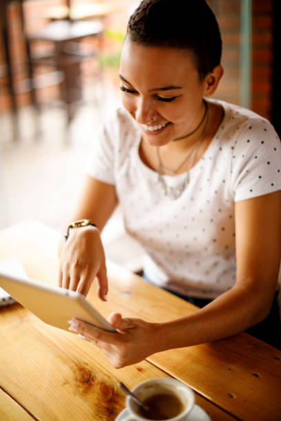 istock Cute smiling girl using digital tablet at a cafe 913689922