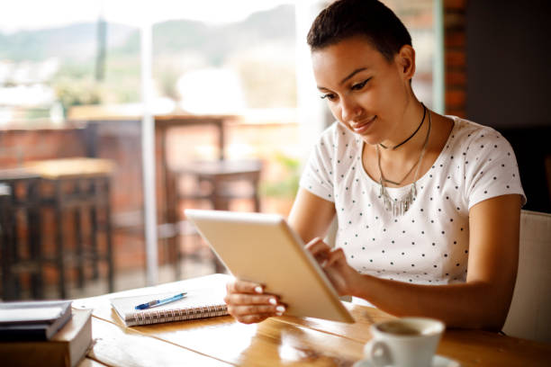 istock Cute smiling girl using digital tablet at a cafe 913689984