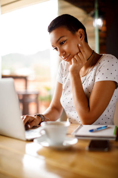 istock Young woman using laptop at a cafe 913693312