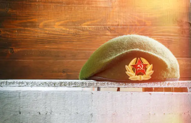 23 February. An army beret of the Russian armed forces, with a metal red star on a wooden background. Copy space