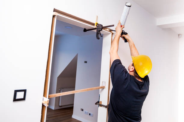 istock Handyman installing door with an mounting foam in a room. 913700672