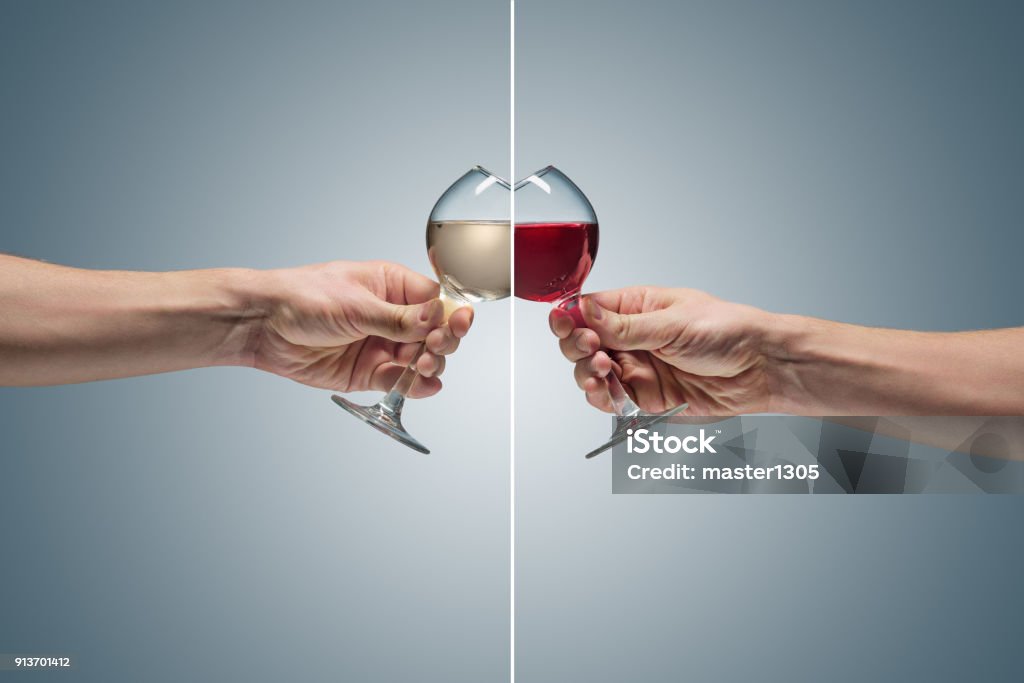 Close-up view of white wine glass Close-up view of two glasses with red and white wine in male hand. concept of confrontation, differences in taste and preference Alcohol - Drink Stock Photo