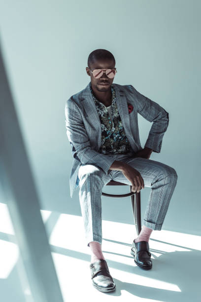 istock Stylish man in suit posing on chair 913701438