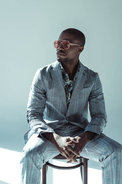 istock Stylish man in sunglasses posing on chair 913701450