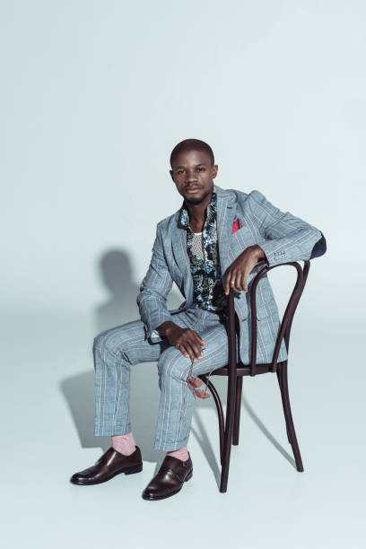 istock man in stylish suit posing on chair 913701548