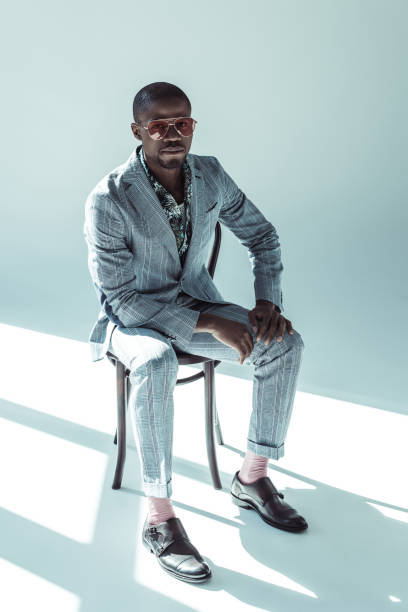 istock Young man in sunglasses posing on chair 913704426