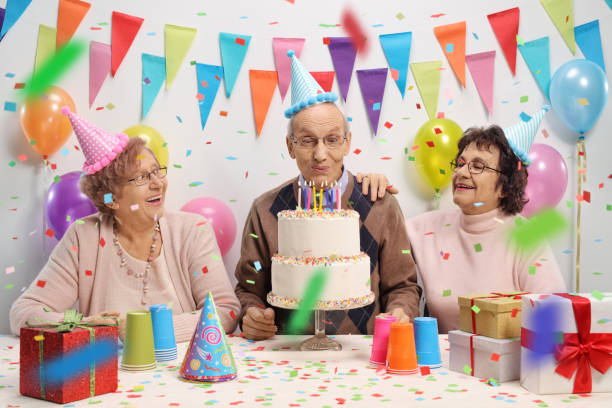 istock Elderly man with two elderly women blowing candles on a birthday cake 913704876