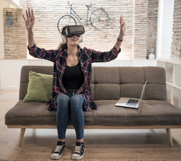 istock Woman with virtual reality glasses at home 913708878