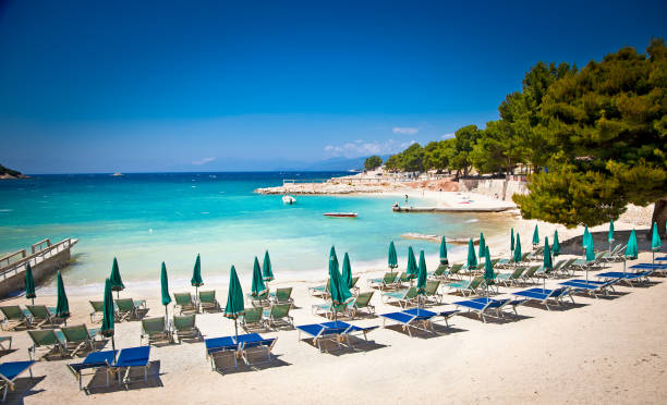 Beautiful beach in Ksamil, Albania. Sunshade umbrellas and deckchairs on the beautiful Ksamil beach, Albania. albania photos stock pictures, royalty-free photos & images