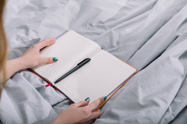 istock cropped image of girl holding open notebook with pen 913717800