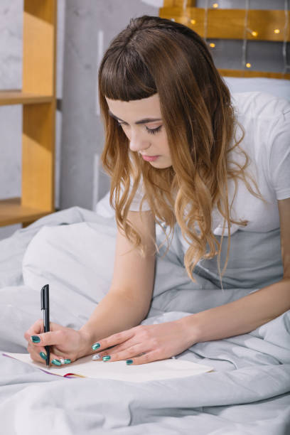 istock girl writing something to notebook in bed in morning 913717866