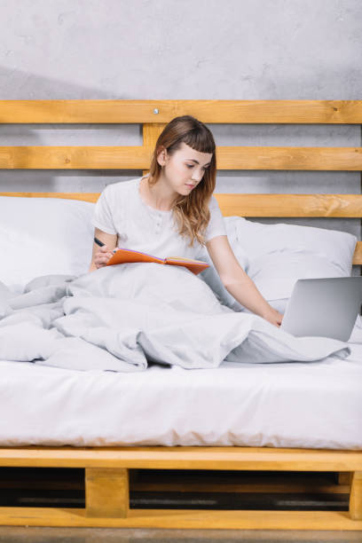 istock girl studying in bed in morning and using laptop 913718222