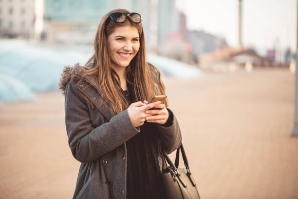 istock Smiling young woman texting on mobile phone 913720652