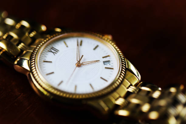 Young woman in formal wear holding a vintage watch.