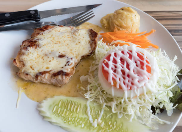 Roasted barbecue steak with the cream cheese sauce on the white plate.