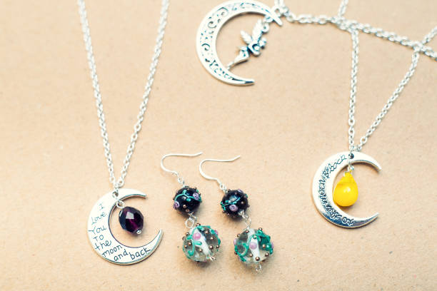 istock Silver charm pendants. Moon figures and letters. 913722178