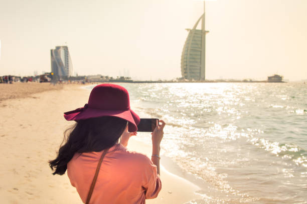 tourist unter bild am berühmten jumeirah beach in dubai, vereinigte arabische emirate - dubai beach hotel skyline stock-fotos und bilder