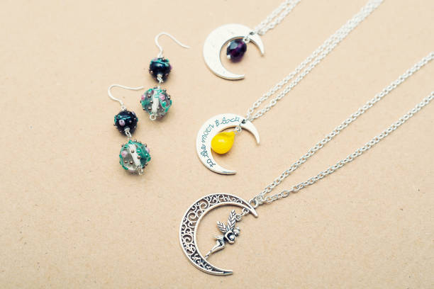 istock Silver charm pendants. Moon figures and letters. 913722602