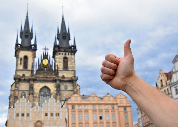 istock Man hand showing thumb up over Prague cityscape 913725262