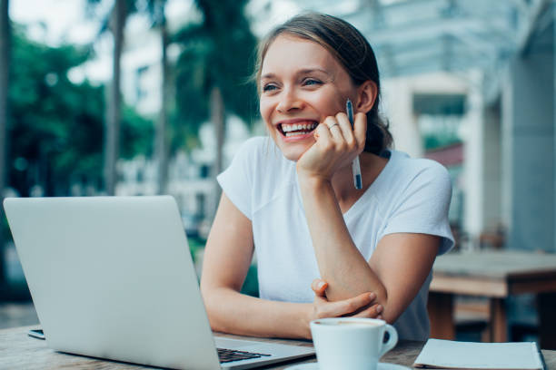 ストリート カフェのラップトップに取り組んで幸せな素敵な女 - outdoors business computer laptop ストックフォトと画像