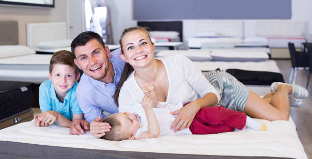 istock parents with two young sons testing mattress in store 913729572