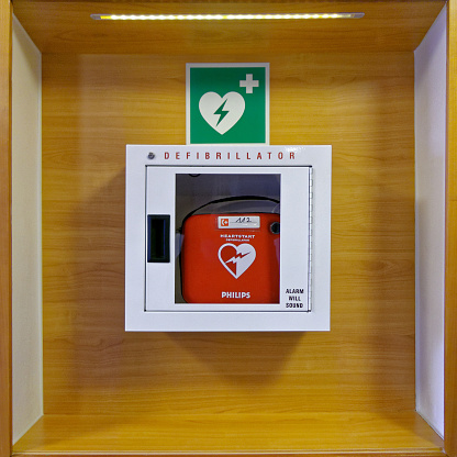 Zirndorf, Germany - January 31, 2018: Red heartstart external Defibrillator hangs on a wooden wall in a white box in a restaurant in Germany, Zirndorf.