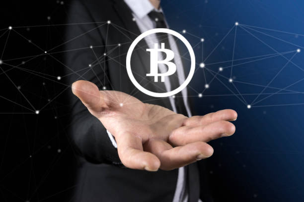 istock Unrecognizable businessman s hands holding a round bitcoin hologram. A blurred blue background. 913746016