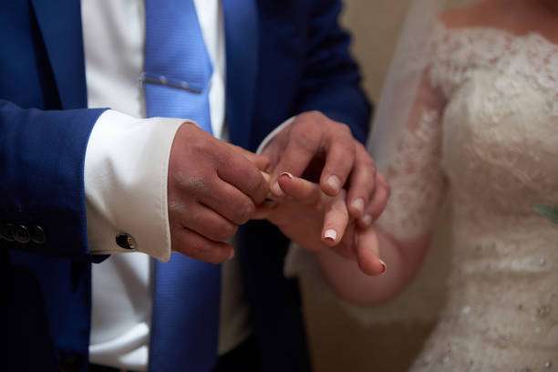 istock Bride and groom exchanging rings 913746122