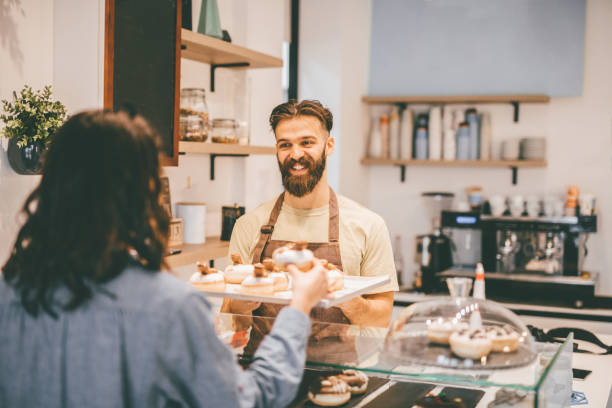 istock Young woman buying donuts 913754314