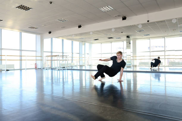 istock Young guy doing physical exercises in black sport suit 913754496